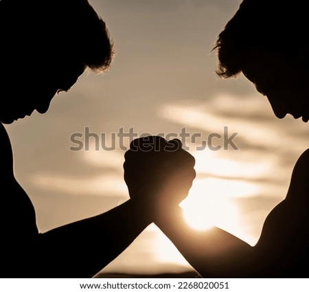 Men measuring forces, arms Two men arm wrestling. Rivalry, vs, challenge, hand wrestling. Sunset, sunrise. Rivalry, closeup of male arm wrestling.