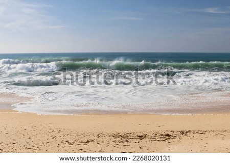 Water spraying off waves in the Atlantic ocean on a warm winter day at a beach near Lisbon, Portugal.