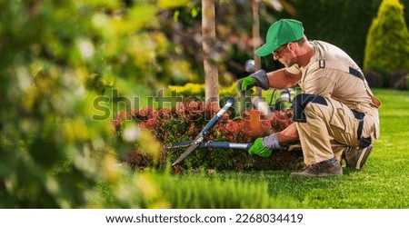 Caucasian Garden and Landscaping Services Contractor in His 40s with Hedge Shears Performing Spring Time Back Yard Maintenance. Royalty-Free Stock Photo #2268034419