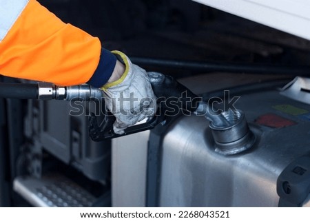heavy duty truck driver refueling diesel fuel tank, diesel, long distance, europe, environment, pollution,  Royalty-Free Stock Photo #2268043521