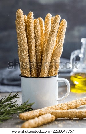Italian grissini bread sticks with sesame seeds on the kitchen table. Royalty-Free Stock Photo #2268047757