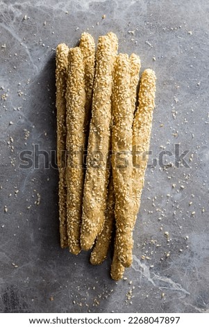 Italian grissini bread sticks with sesame seeds on the kitchen table. Top view.
