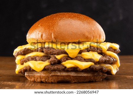 triple smash burger ith cheddar cheese in wood table Royalty-Free Stock Photo #2268056947