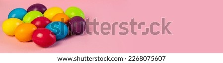 Wide Easter banner empty. Multi-colored eggs on a pink background. Holiday concept, congratulation, postcard, template,copy space, text, moc-up,handmade,spring,decoration,party,poste, blank, party.