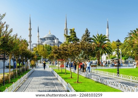 Awesome view of the Sultan Ahmed Mosque (the Blue Mosque) among green gardens. Tourists and residents rest and walk along scenic city park. Royalty-Free Stock Photo #2268103259