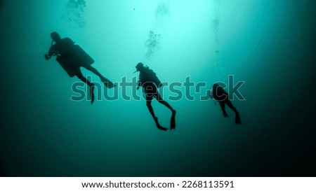 silhouette of a technical dive guide and two tourists. cenote diving, unrecognizable people Royalty-Free Stock Photo #2268113591