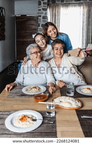 hispanic Multi Generation women Family Posing For photo Selfie at dinner time At Home Together in Latin America