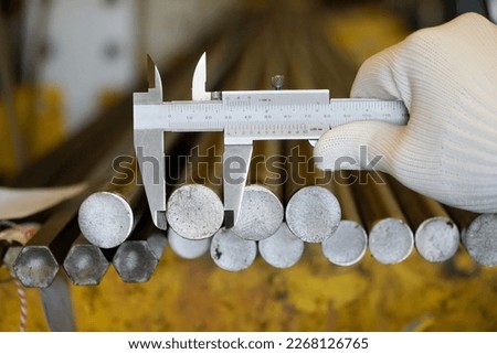 Measuring tool and equipment,mechanic measuring the size of a round steel shaft in a factory