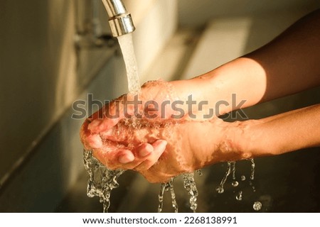Woman's hands washing hands in a sink Cleaning and preventing germs from touching hands health concept
