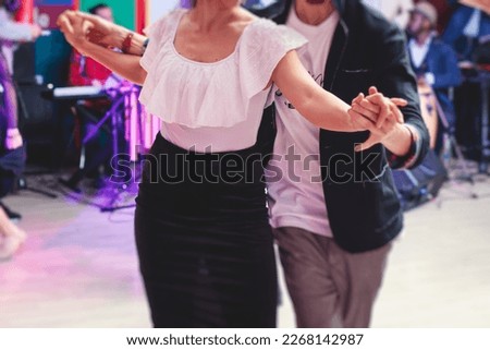 Couples dancing traditional latin argentinian dance milonga in the ballroom, tango salsa bachata kizomba lesson in the red and purple lights, festival, lesson class in dance school class academy
 Royalty-Free Stock Photo #2268142987