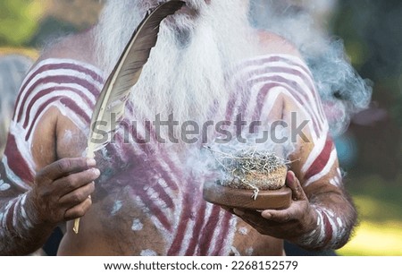Australian Aboriginal smoking ceremony, mans hand is holding the smoke of burning plants, the ritual rite at the community event, symbol of indigenous culture and traditions Royalty-Free Stock Photo #2268152579
