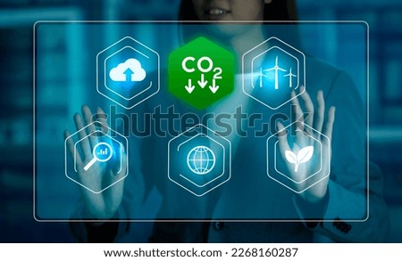 Businesswoman working virtual screen to reduce CO2 emissions carbon footprint climate change to limit global warming. Sustainable development and innovation green technology business concept.