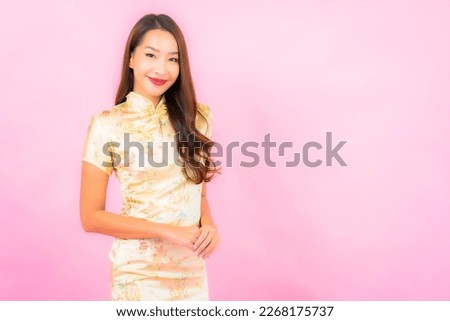 Portrait beautiful young asian woman smile in action with chinese new year concept on pink color background