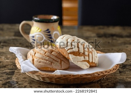 Chocolate and vanilla bread in front of a traditional Mexican cup of coffee. shells Royalty-Free Stock Photo #2268192841