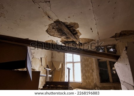 Abandoned place Residential house: Dark room with light window and collapsed ceiling and old junk. Royalty-Free Stock Photo #2268196883