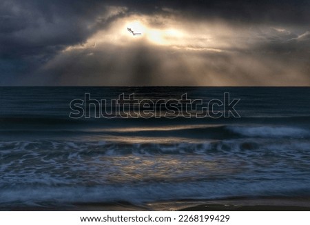 In the middle of the storm, the sun becomes hollow between the clouds, reflecting the sea.