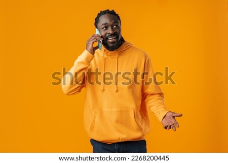 Young black man making a phone call against yellow background Royalty-Free Stock Photo #2268200445