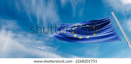 Flag of the European Union waving in the wind on flagpole against background of the sunrise, banner, close-up Royalty-Free Stock Photo #2268201751