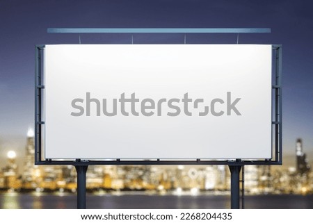 Blank white billboard on city buildings background at night, front view. Mockup, advertising concept