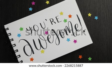 YOU'RE AWESOME! lettering in notebook with colorful stars