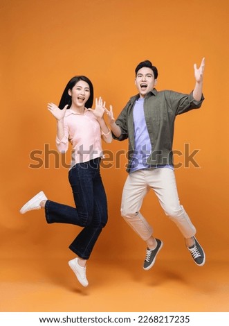 Young Asian couple standing on background Royalty-Free Stock Photo #2268217235