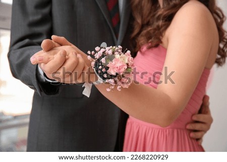 Young man and his prom date with corsage holding hands, closeup Royalty-Free Stock Photo #2268220929