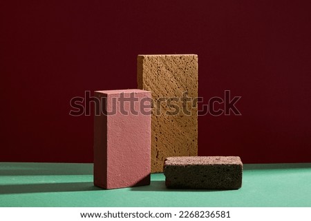Abstract minimal concept - empty podium and two dark bricks on dark background. Empty space for display cosmetic or product. Front view.