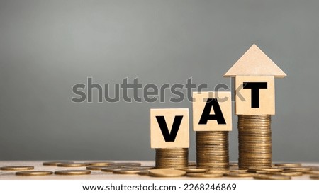 VAT Concept with wooden block and home symbol on stacked coins.Income tax return.savings money of coins to buy a home concept for property, mortgage. Royalty-Free Stock Photo #2268246869