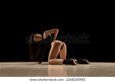 Passion Young woman in bodysuit and heels dancing, performing over black background. Concept of contemporary dance style, art, aesthetics, hobby, creative lifestyle