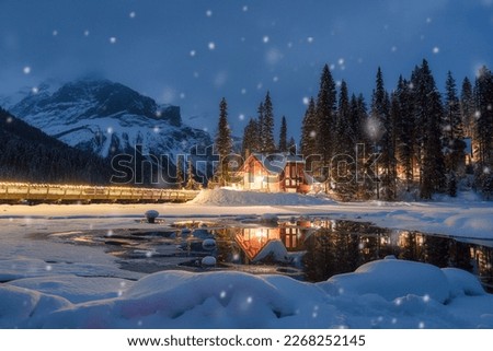 Beautiful view of Emerald Lake with wooden lodge glowing and snowfall in pine forest on winter at Yoho national park, Alberta, Canada Royalty-Free Stock Photo #2268252145
