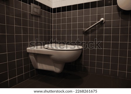 Clean ceramic toilet bowl near tiled wall indoors
