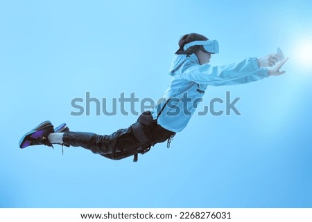 World of future. A modern teenage boy flies through the air wearing virtual reality glasses, immersing himself in the game. Background with a glowing energy field. Virtual reality games. 