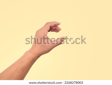 Close up of empty hand showing in various gestures, holding things, hand holding, telephone paper, card, coin, water bottle, small and large size, isolated on primrose background and practical concept