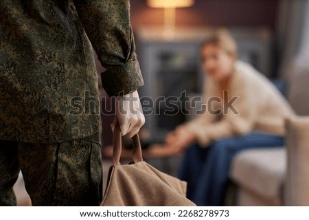 Close up of husband coming back home from army, wife waiting in background, copy space