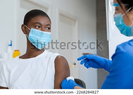 African American Woman get vaccine from female doctor in clinic.