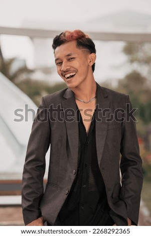 a grown man in a gray suit posing around a cafe table in a very manly and masculine manner before entering the office at noon