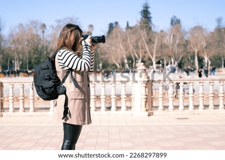 young woman sightseeing and taking photos in seville's plaza de 