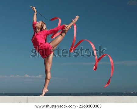 sports woman rhythmic gymnast with red ribbon