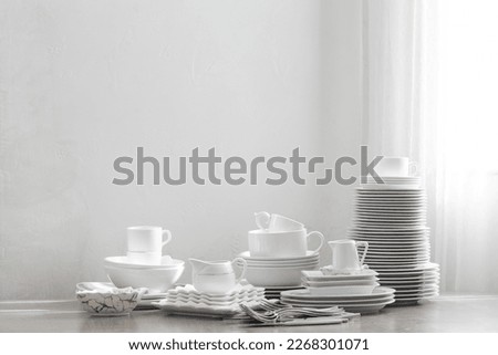 various cutlery on a wooden table against a white wall