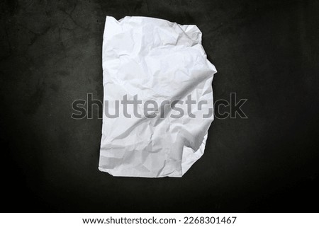 Crumbled paper top view close-up of crumpled sheet of white paper. Top view textured paper background, dark concrete texture. space for text copy space Royalty-Free Stock Photo #2268301467