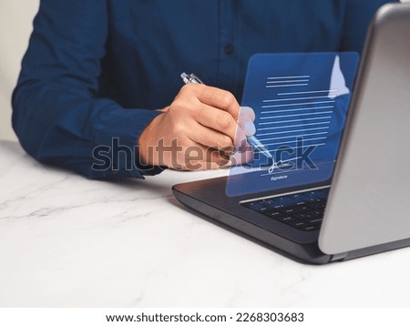 Signature electronic concept. A businessman uses a pen to sign electronic documents on a virtual screen while sitting at the table in the office. Technology, document management, and paperless office Royalty-Free Stock Photo #2268303683