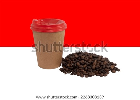 Disposable paper cup of coffee on the background of the national flag of Indonesia (close-up). The largest exporterof coffee in the world. Indonesian coffee. Product supply concept