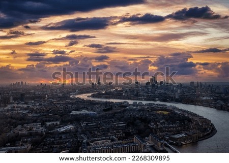 Wide panoramic view of the illuminated, urban skyline of London, England, during a winter sunset