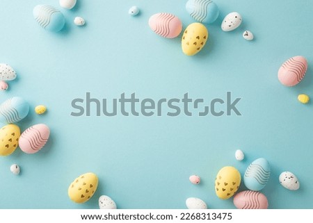 Easter party concept. Top view photo of composition of colorful quail eggs on isolated pastel blue background with empty space in the middle