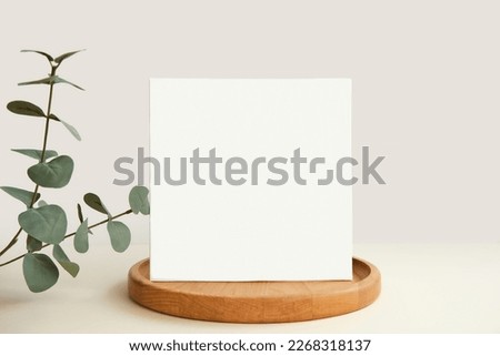 Blank Greeting Card, Invitation Mockup. Front view Eucalyptus Plant, Modern Wooden Plate, Boho Paper Mock Up on Gray Table. Copy Space. Minimal Business Brand Template. Soft Shadow Nordic Flier Design