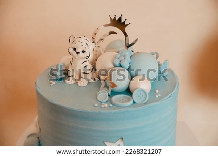 Blue cake on a baby holiday. Birthday boy with balls