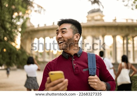 happy asian japanese tourist visiting european city at sunset, using smartphone to look at city map