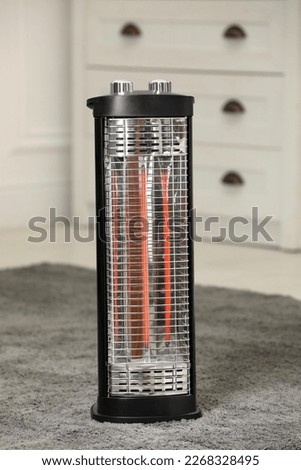 Modern infrared heater on carpet in room Royalty-Free Stock Photo #2268328495