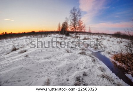Sunset near winter river. Photographed in the forest in Russia in the 60 km from Moscow