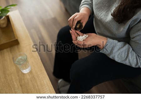 Close up of an overweight woman with a bottle of pills suffering from substance abuse and mental health problems Royalty-Free Stock Photo #2268337757